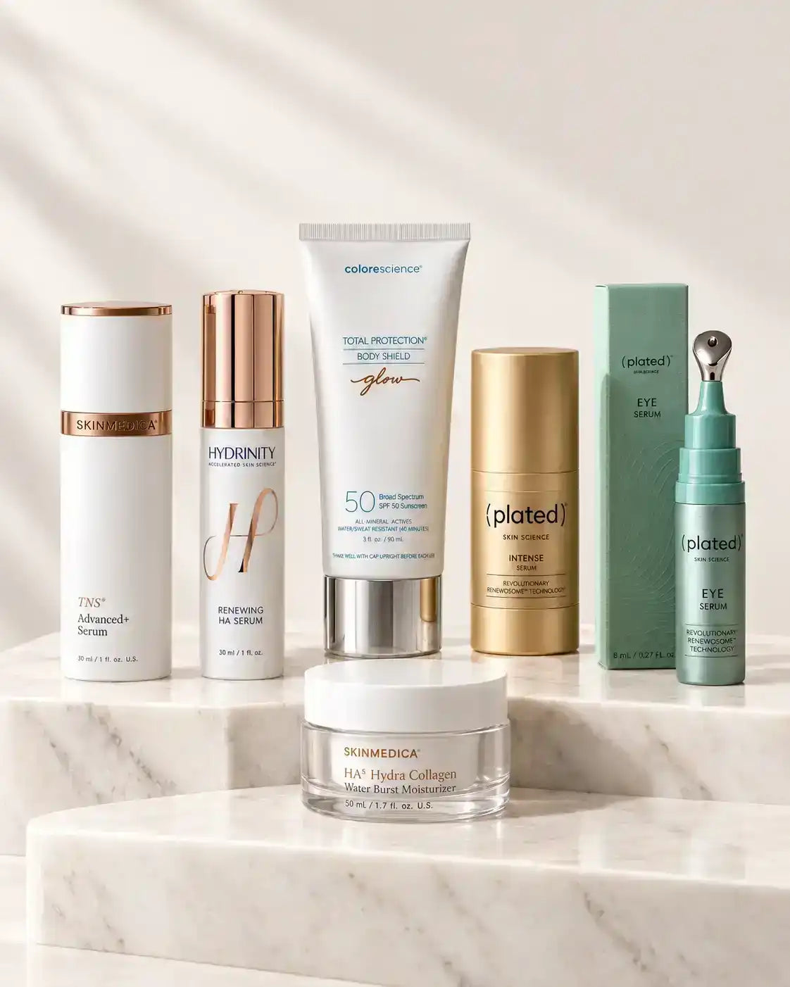 Assortment of SkinMedica, Hydrinity, Colorescience, and Plated skincare products on marble steps.
