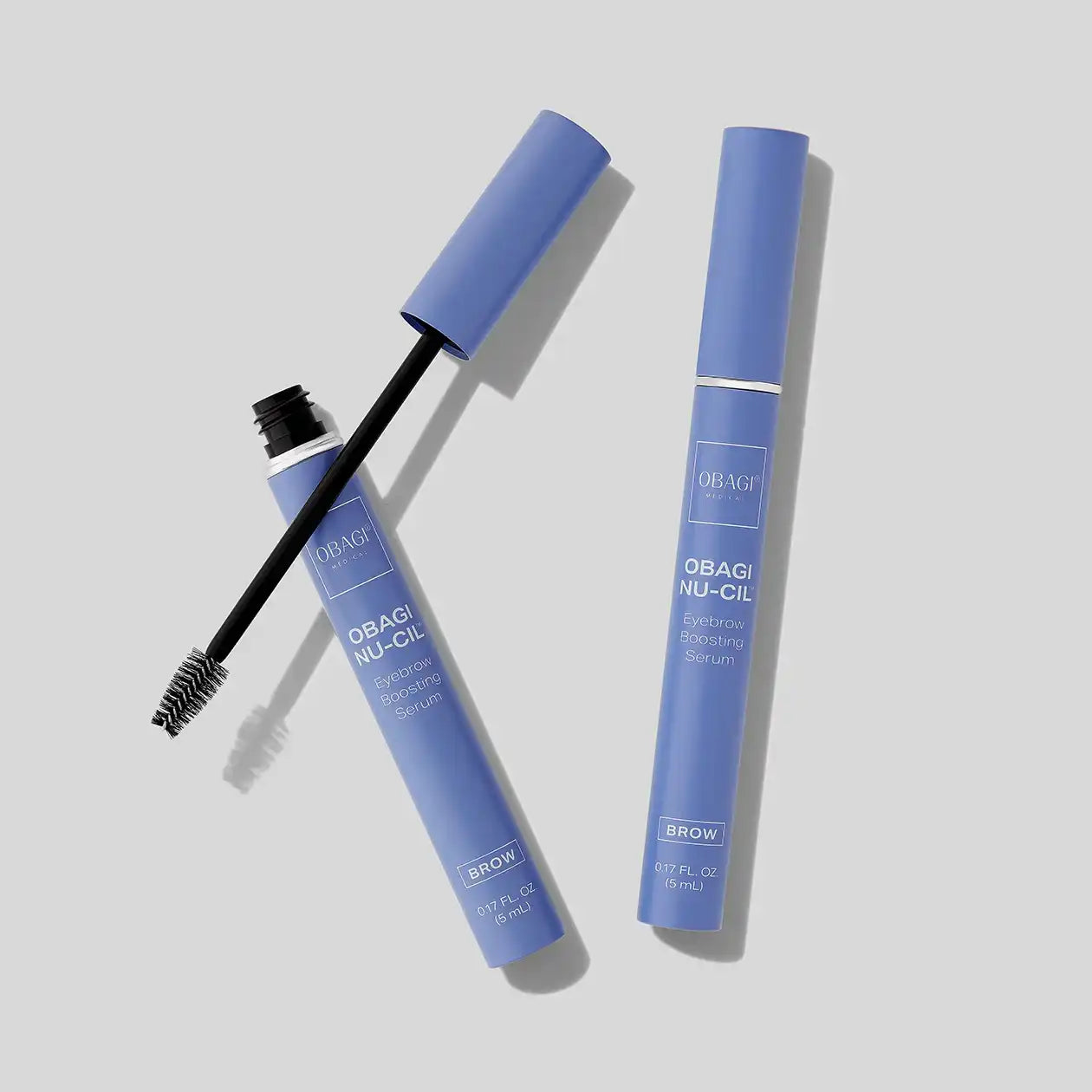 Obagi Nu-Cil Eyebrow Boosting Serum with spoolie applicator on light background