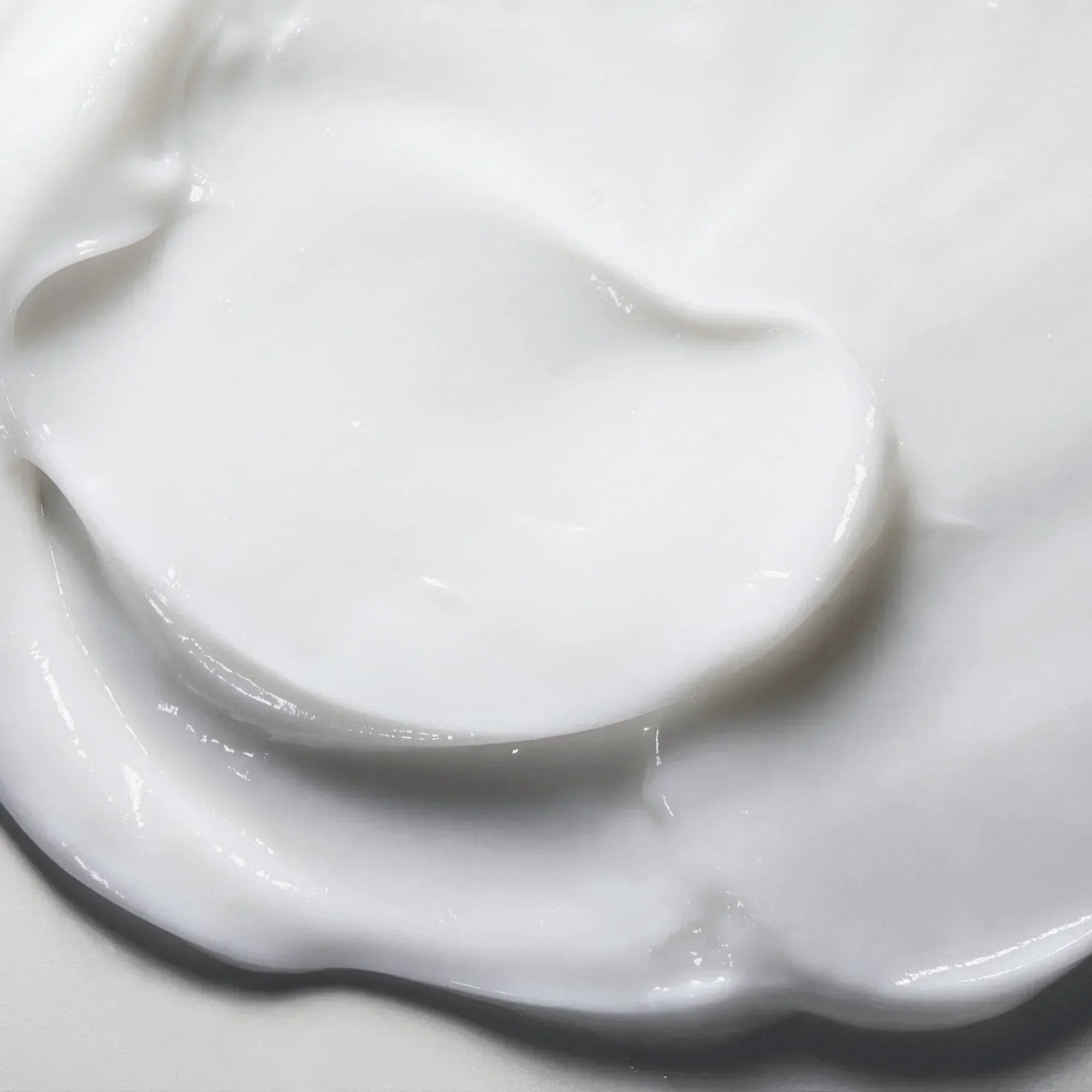 Close-up of creamy white skincare moisturizer texture, smooth hydrating face cream
