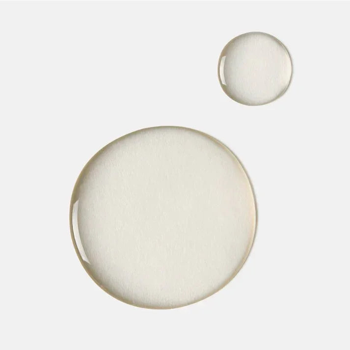 Clear mandelic acid cleanser serum drops on white background, skincare product texture
