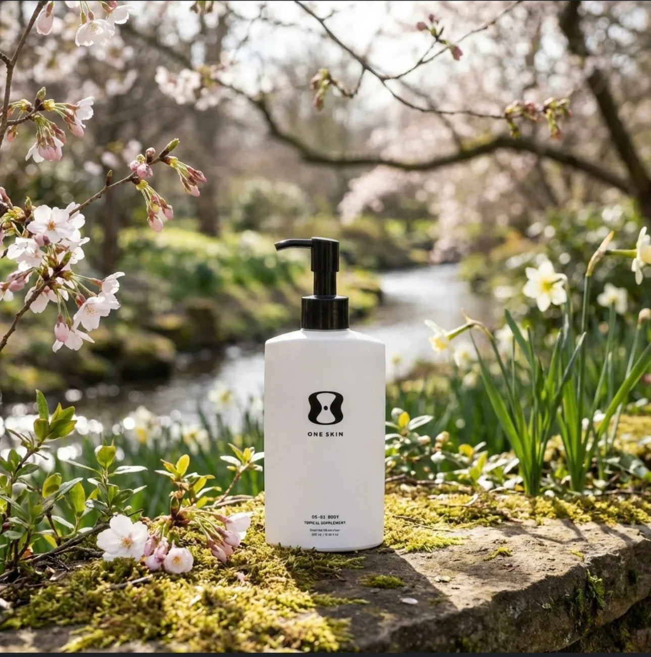 OneSkin body moisturizer bottle outdoors on mossy stone, surrounded by blooming flowers and trees