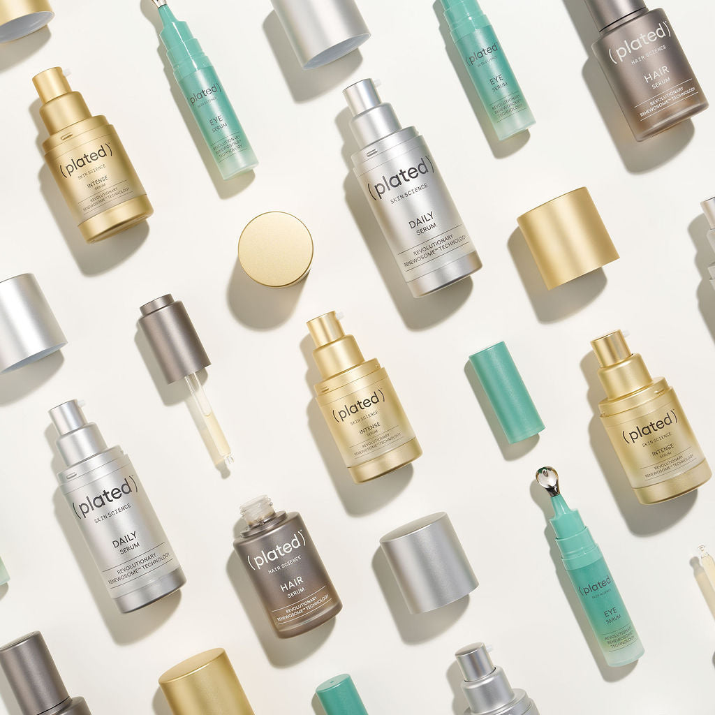 Assorted Plated skincare and hair serum bottles arranged on a light background.