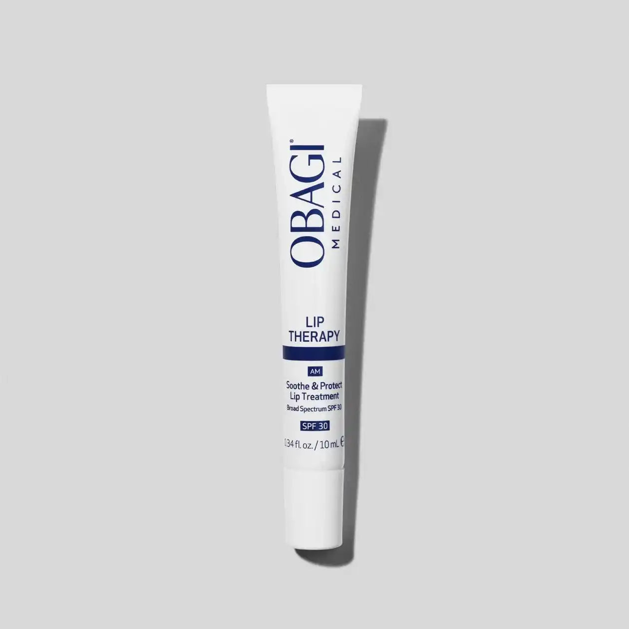 Tube of lip therapy treatment with SPF 30, white packaging on a light gray background