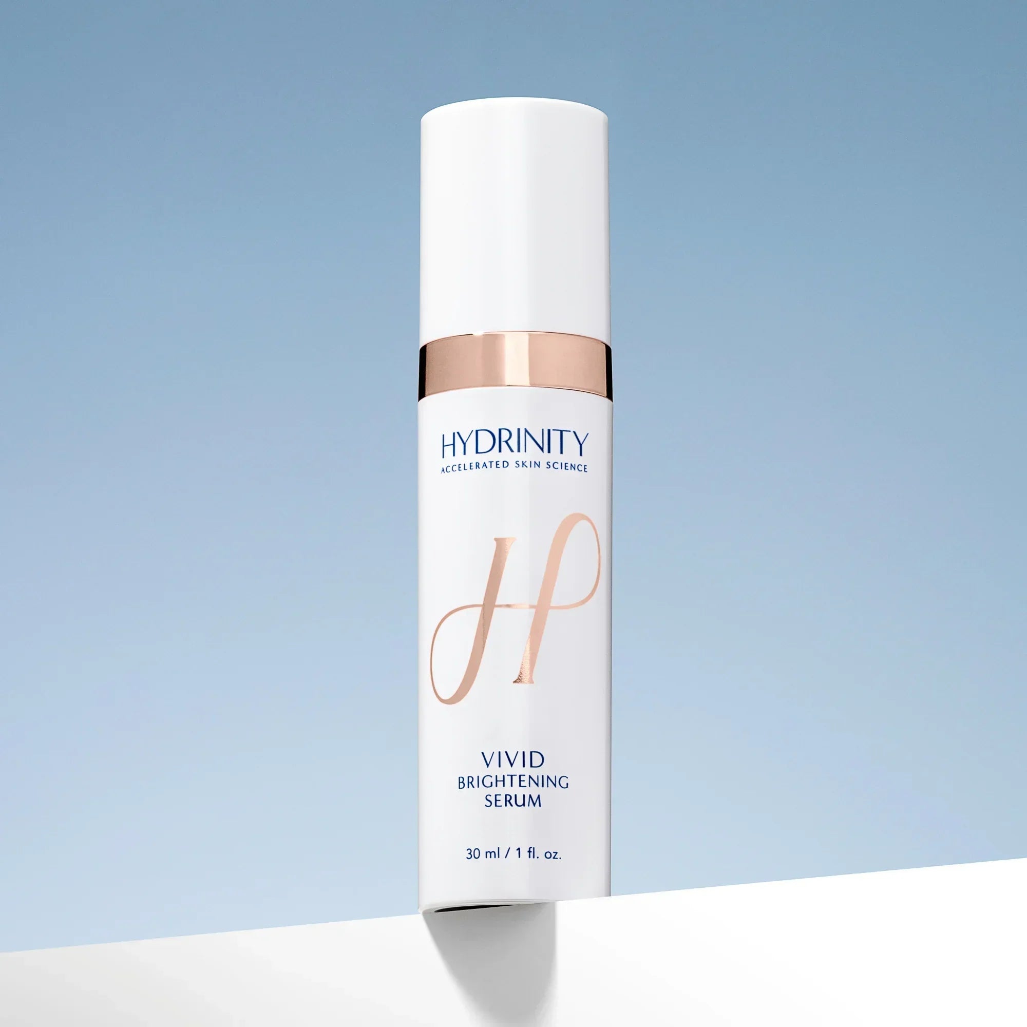 Hydrinity Vivid Brightening Serum bottle on blue gradient background, skincare product