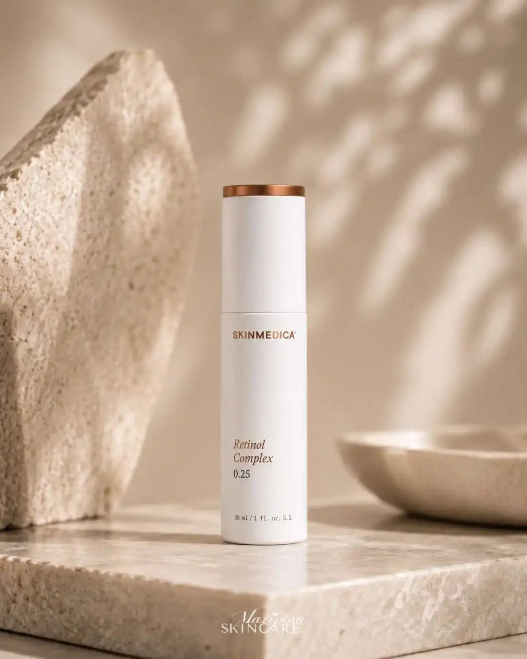 SkinMedica Retinol Complex 0.25 white serum bottle on a stone pedestal with sunlight shadows.