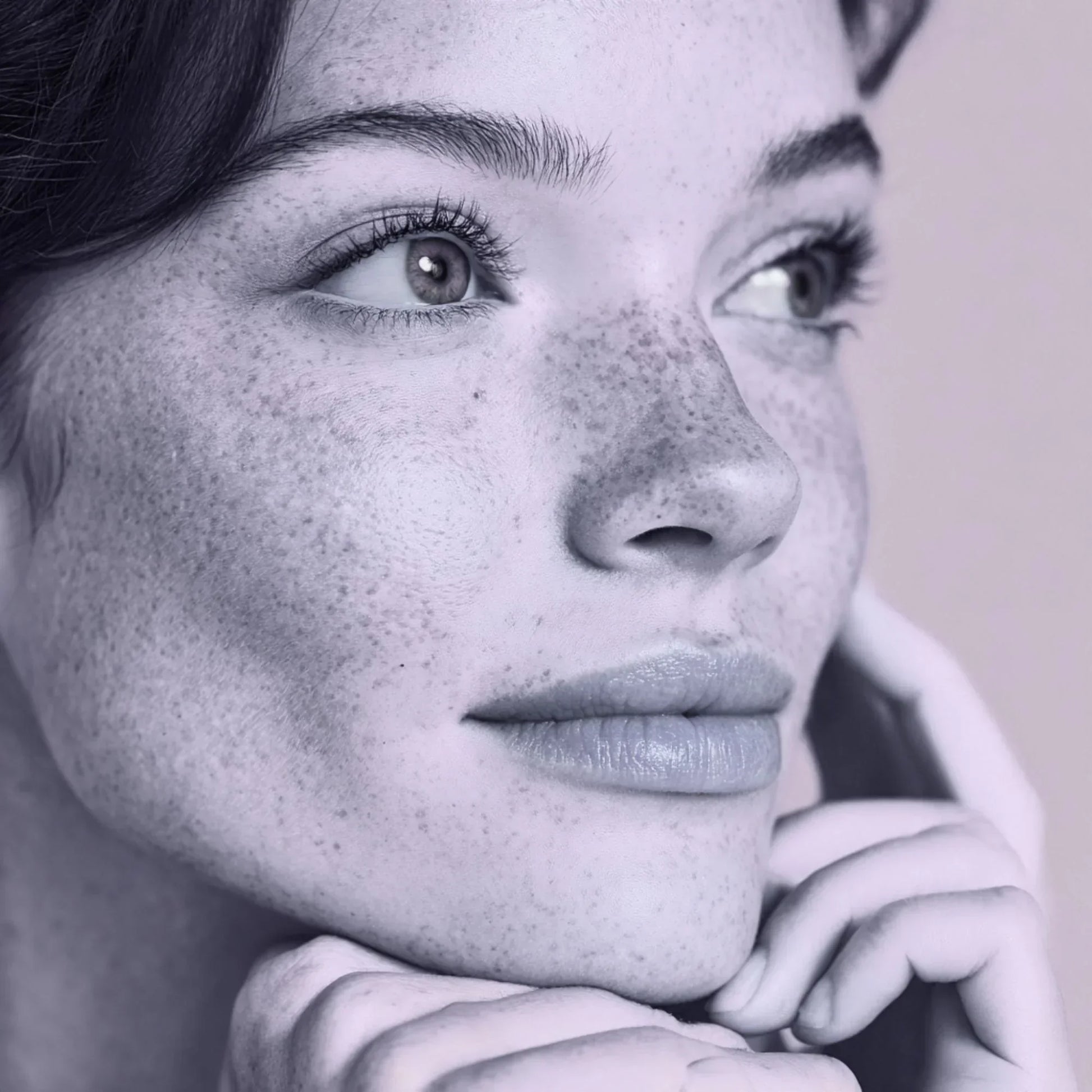 Close-up of woman's face with clear skin, natural freckles, and subtle makeup