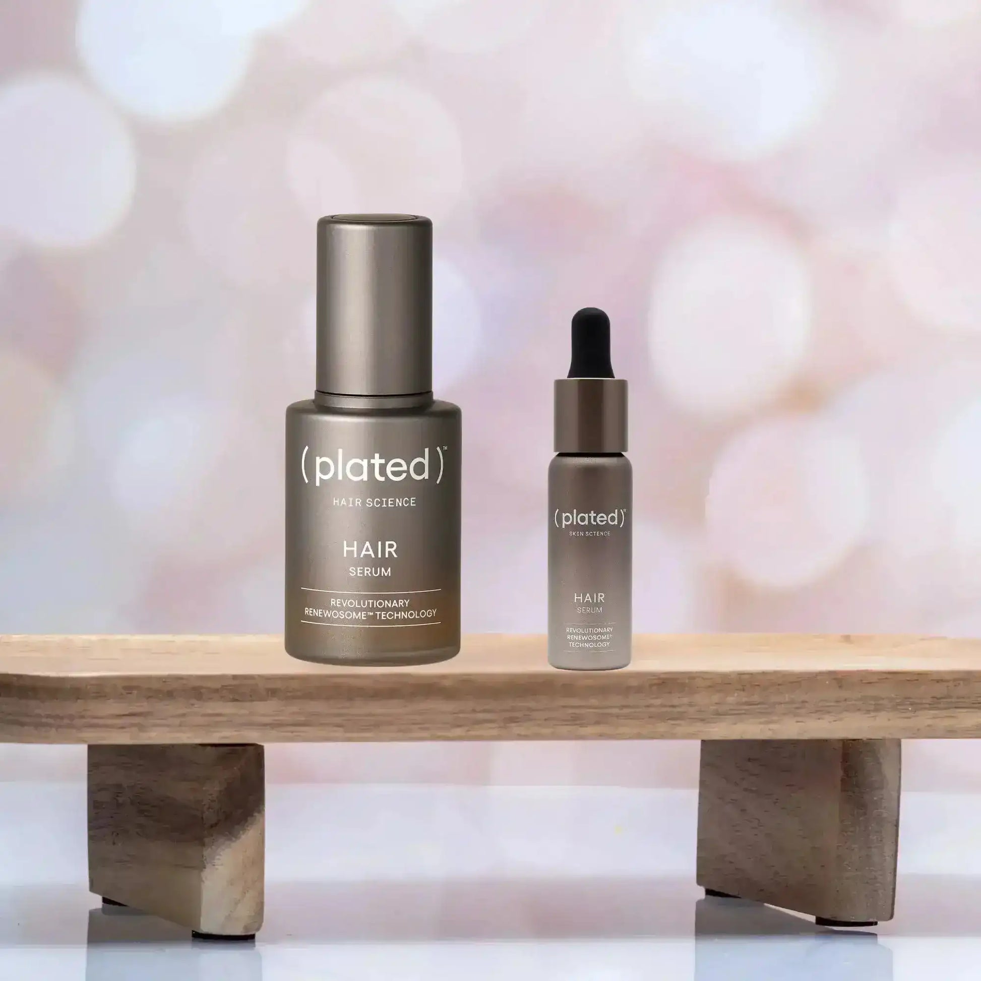 Plated Hair Science Serum with Renewosome Technology on wooden stand