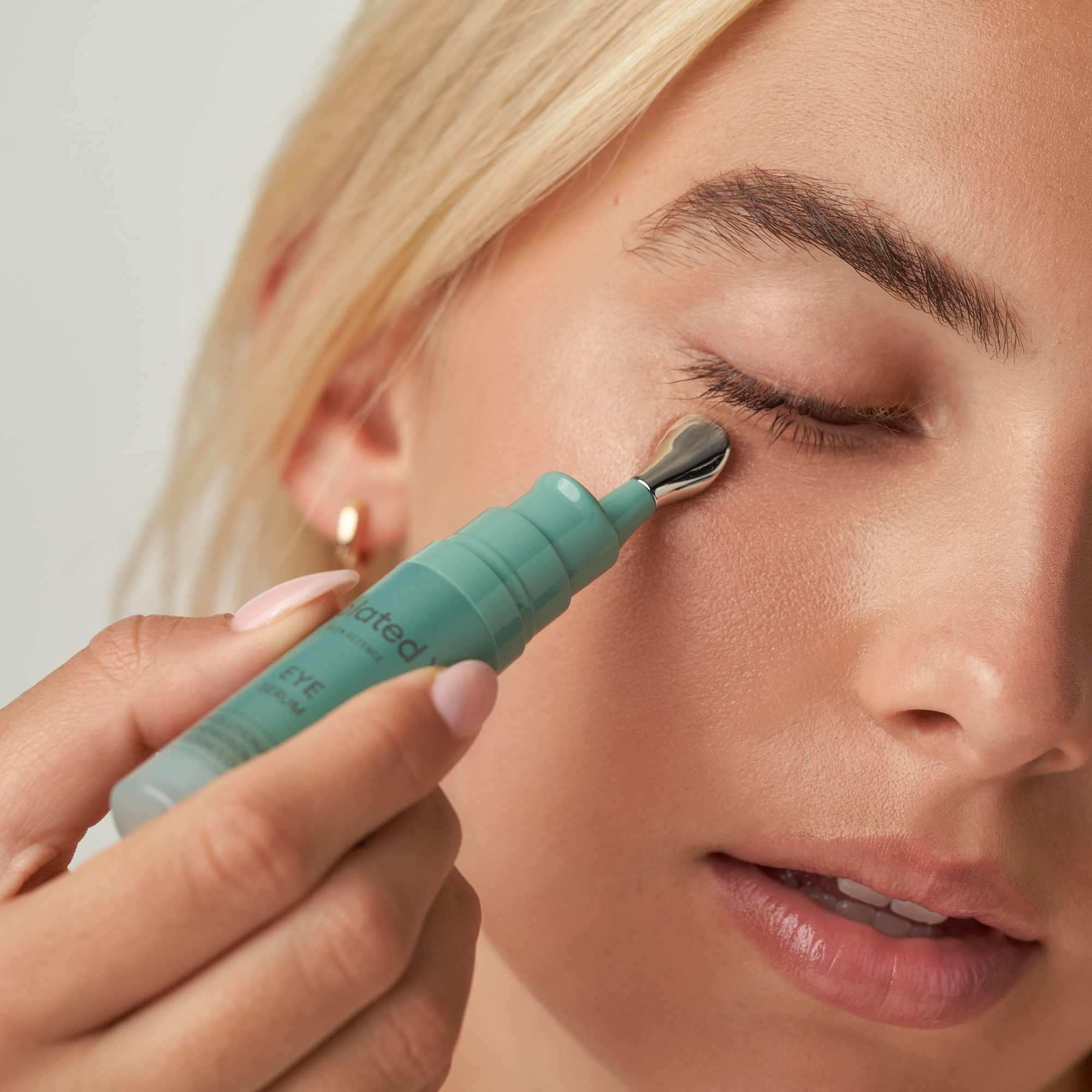 Applying eye serum with a roller applicator for skincare routine