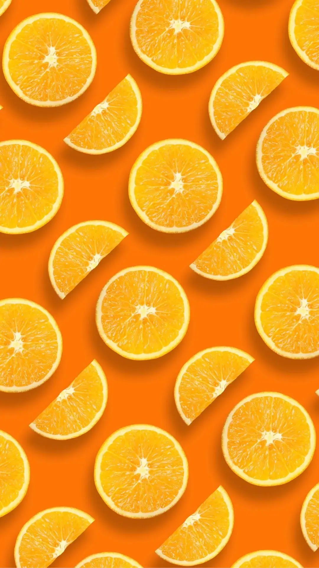 Sliced fresh oranges on bright orange background for skincare and wellness theme