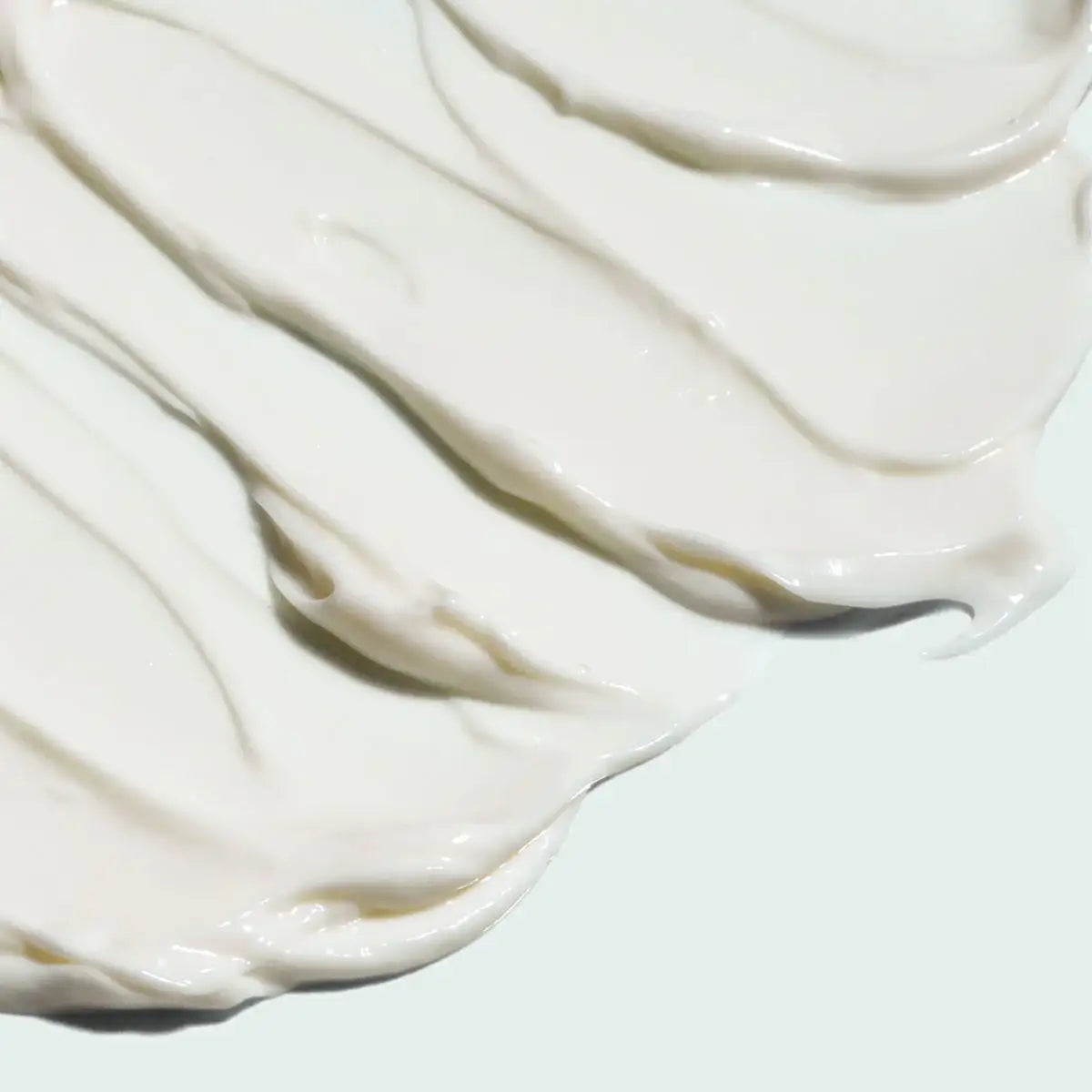 Close-up of creamy white hydrating repair moisturizer texture spread smoothly