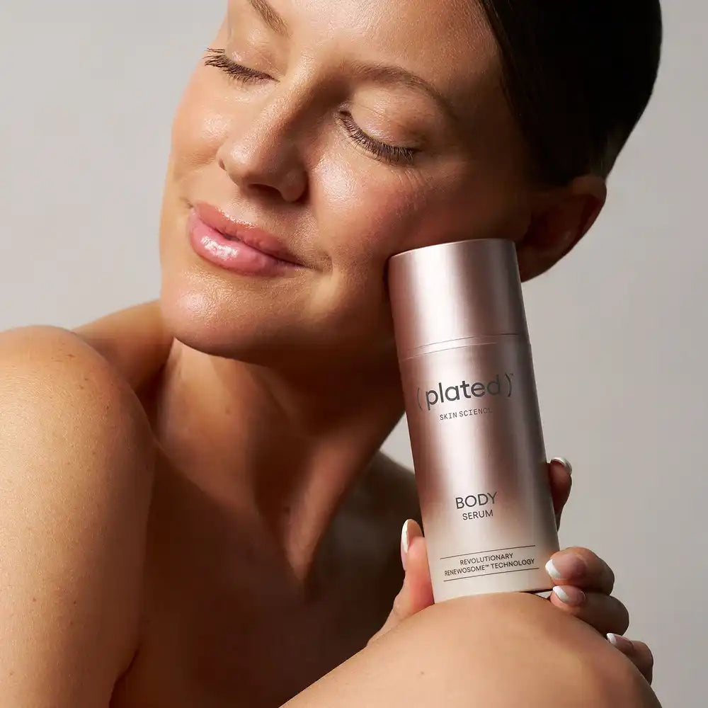 Plated Skin Science Body Serum with Renewosome Technology held by woman with glowing skin